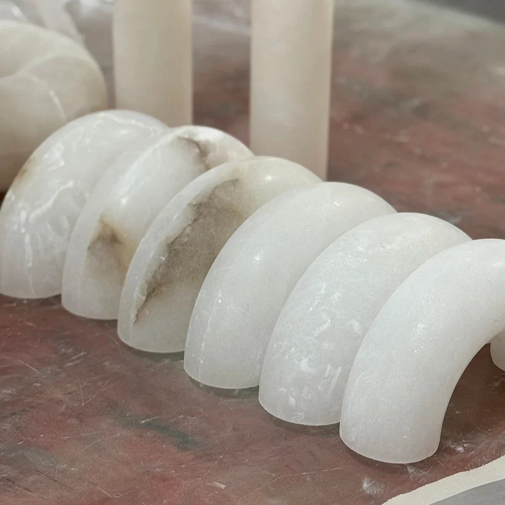 A row of curved alabaster forms showing variations in tone and veining.