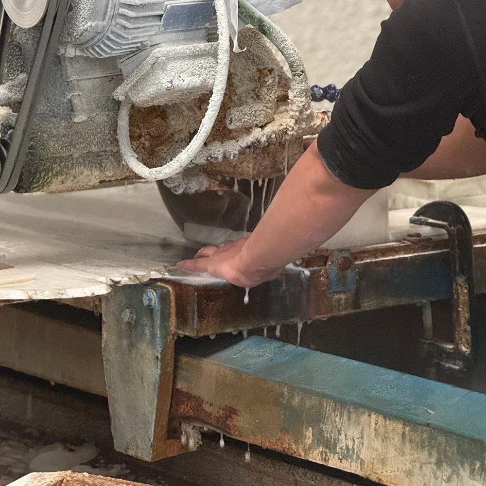 Stone being cut on a workshop saw table.