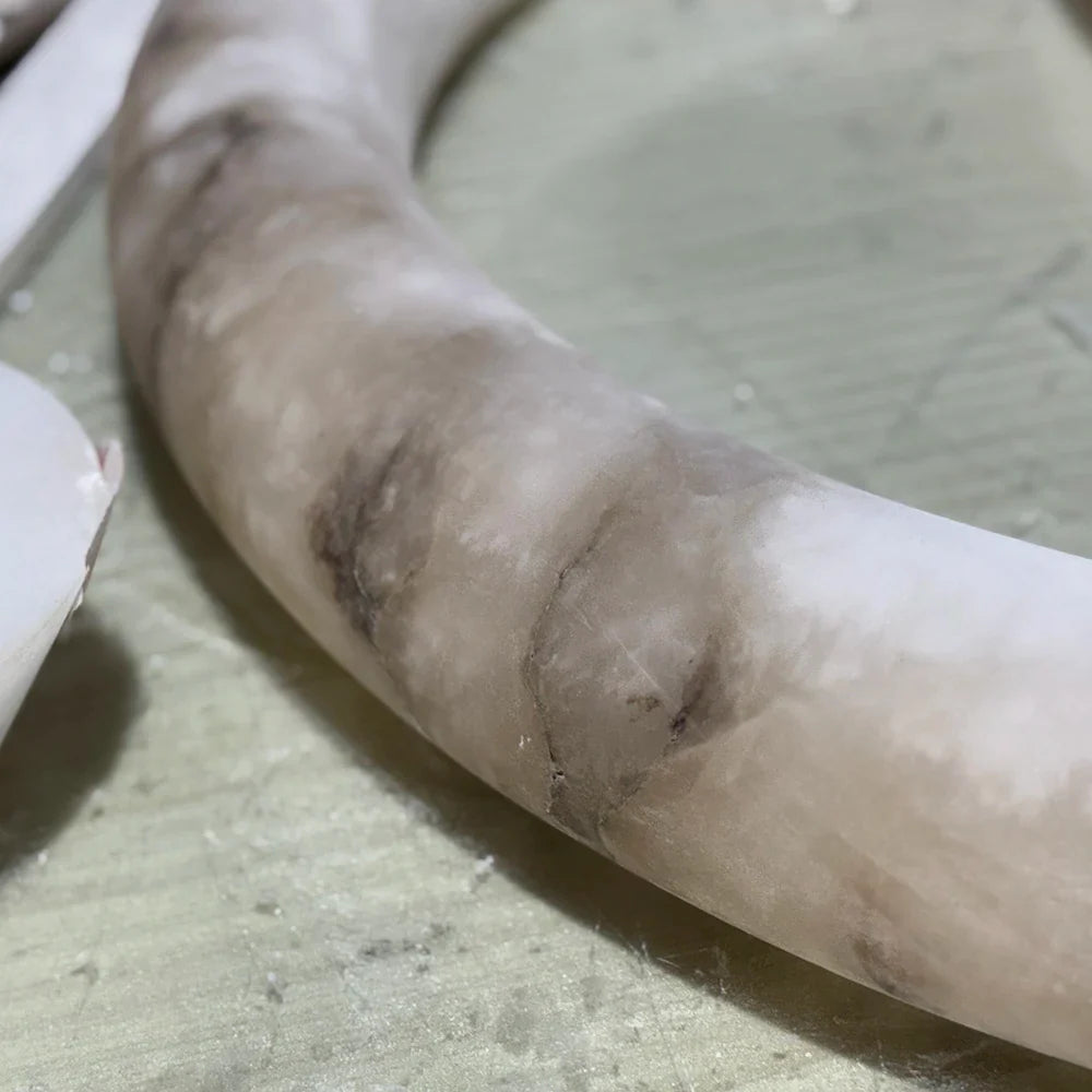 Close view of smoky natural veining in a curved alabaster component.