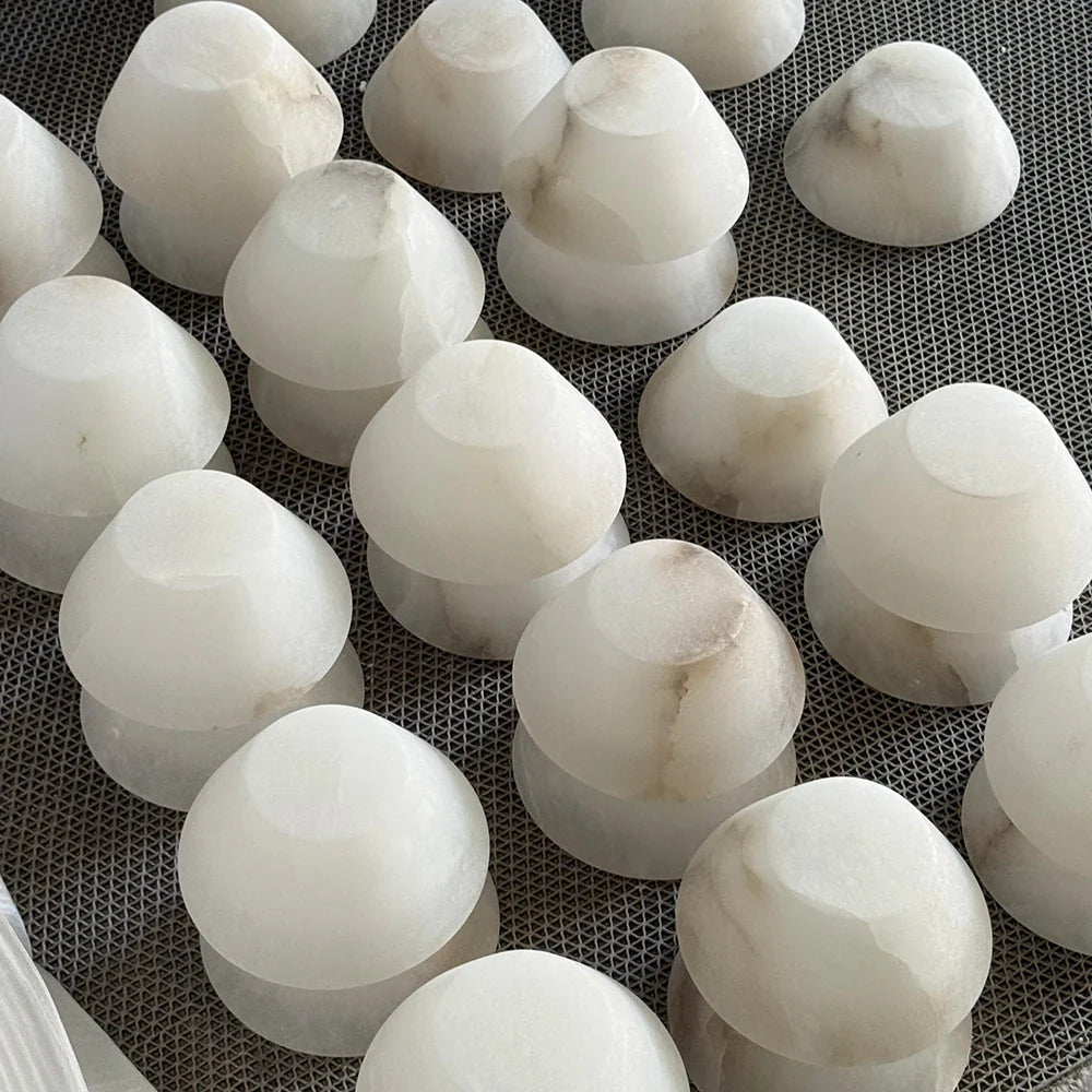 Rounded alabaster forms with subtle differences in tone and mineral markings.