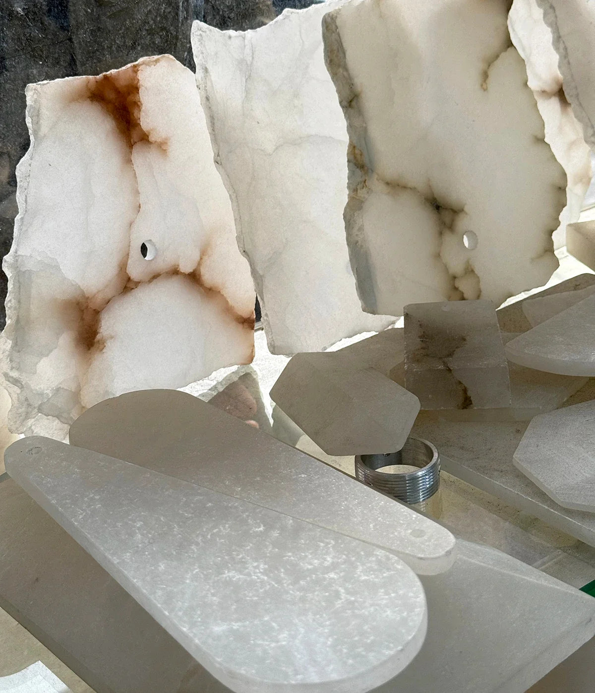 Translucent alabaster slabs with rough edges and contrasting natural veining.